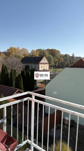 Predaj: 3-i mezonet v krásnom, zelenom prostredí v Tomášikove 71m2 - Výhľad z 3-izbového bytu v Tomášikove ukazuje záhrady a starú budovu.