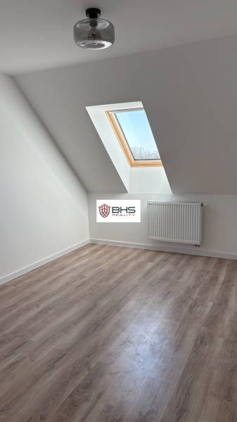 Predaj: 3-i mezonet v krásnom, zelenom prostredí v Tomášikove 71m2 - Podkrovná izba s podlahou s dreveným dekorom a strešným oknom v 3-izbovom byte.