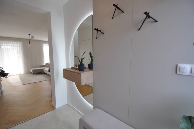 Perla v mori priemernosti - 4i prémiový RD Miloslavov - Interiér rodinného domu s podlahou s dreveným dekorom, zrkadlom a izbovými rastlinami.