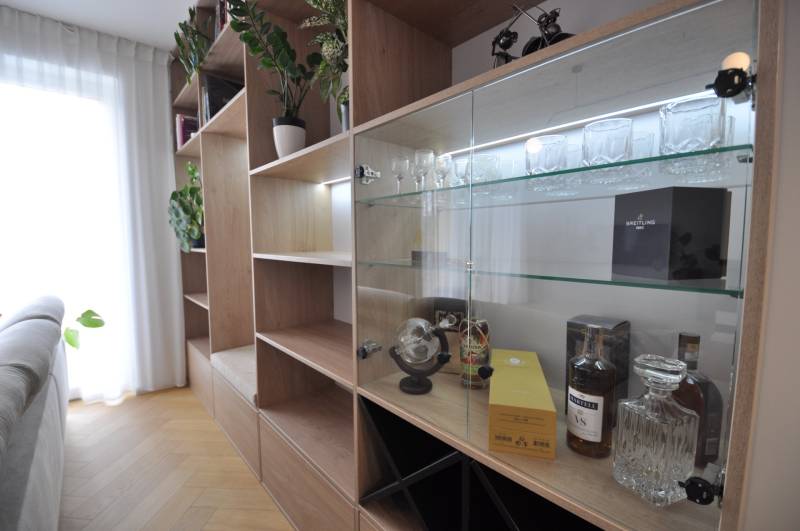 Perla v mori priemernosti - 4i prémiový RD Miloslavov - Interiér rodinného domu so skriňou, sklenenými policami a podlahou s dreveným dekorom.