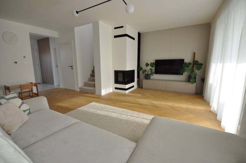 Perla v mori priemernosti - 4i prémiový RD Miloslavov - Obývacia izba v rodinnom dome s krbom a podlahou s dreveným dekorom.