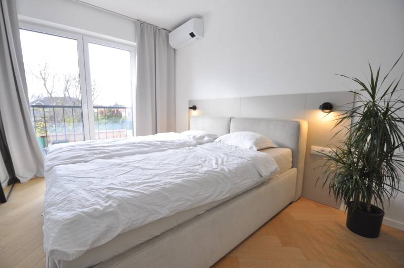 Perla v mori priemernosti - 4i prémiový RD Miloslavov - Spálňa v rodinnom dome s posteľou, rastlinou a podlahou s dreveným dekorom.