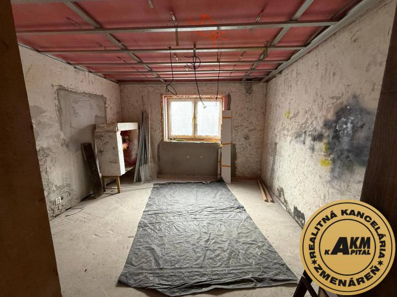 Rodinný dom na predaj, Stará Kremnička, okres Žiar nad Hronom  - Miestnosť v rekonštrukcii v rodinnom dome s podlahou s dreveným dekorom.