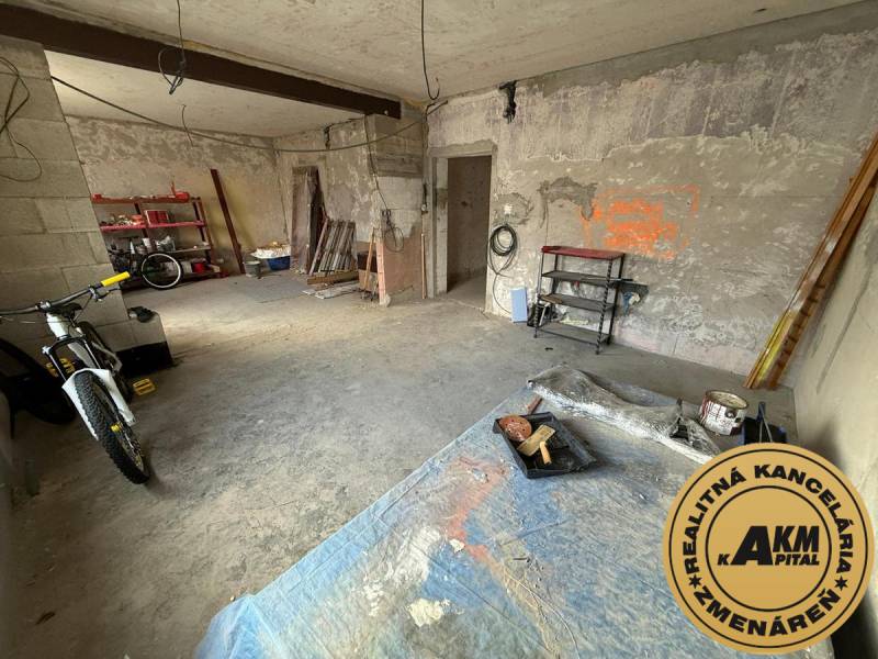 Rodinný dom na predaj, Stará Kremnička, okres Žiar nad Hronom  - Nedokončená miestnosť v rodinnom dome s bicyklom a regálmi pre rôzne nástroje.
