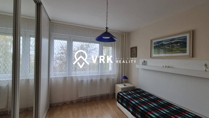 3 IZBOVÝ BYT, OVRUČSKÁ, KOŠICE - SÍDL. DARGOVSKÝCH HRDINOV - Pokoj v 3-izbovom byte s podlahou s dreveným dekorom a modrým svietidlom.