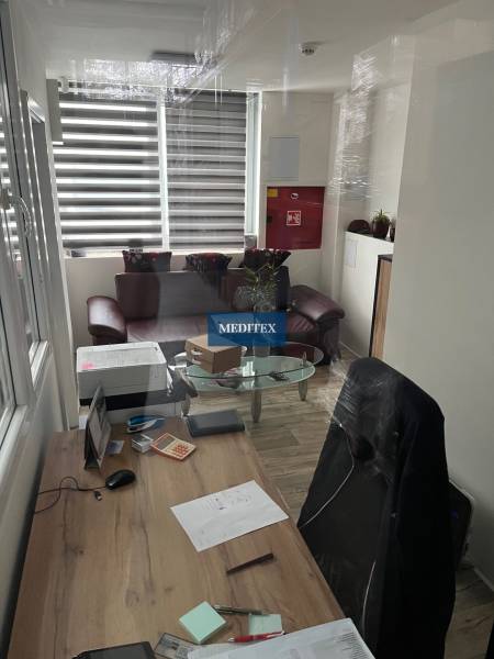 Sklad na prenájom o ploche 121 m2 s malou kanceláriou a WC - Kancelária v skladoch a halách s písacím stolom a podlahou s dreveným dekorom.