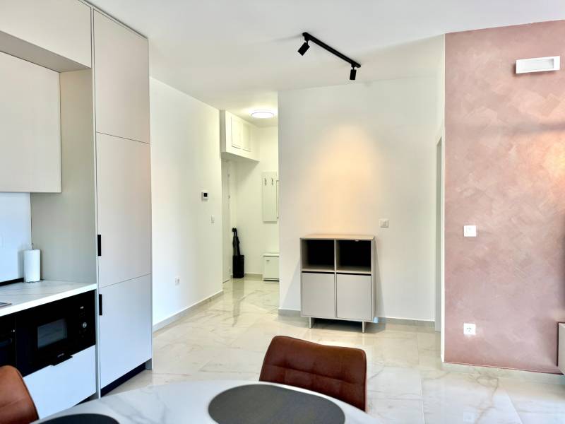 Apartmán s výhľadom na more BAR, Čierna Hora-Montenegro - Interiér 1-izbového bytu s kuchynskou linkou, jedálenským stolom a svetlými stenami.