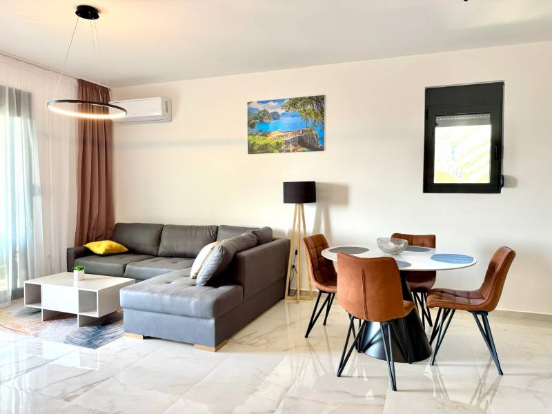 Apartmán s výhľadom na more BAR, Čierna Hora-Montenegro - Obývacia izba v 1-izbovom byte s podlahou s dreveným dekorom, sedacou súpravou a jedálenským stolom.