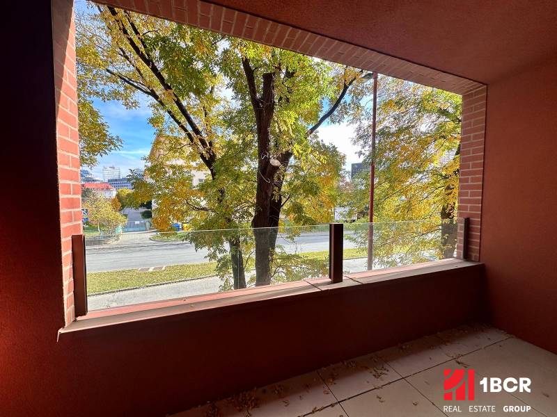 PRIESTRANNÝ 1-IZB. BYT S LOGGIOU V IKONICKOM PROJEKTE ZWIRN III - Výhľad z balkóna na zeleň a cestu v Bratislave - Ružinove na Košickej ulici.