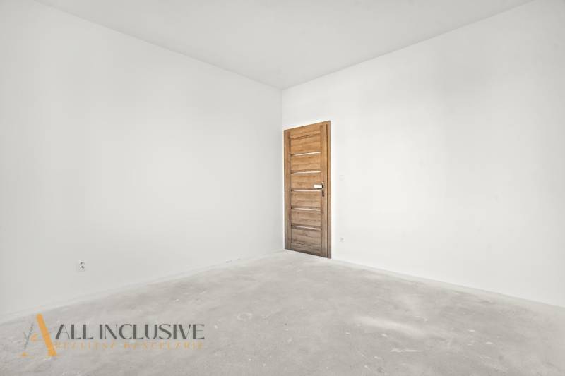 NA PREDAJ 4-IZB.BUNGALOV S DVOJGARÁŽOU,ORECHOVÁ POTôŇ - Prázdna izba v rodinnom dome s bielymi stenami a dverami s dreveným dekorom.