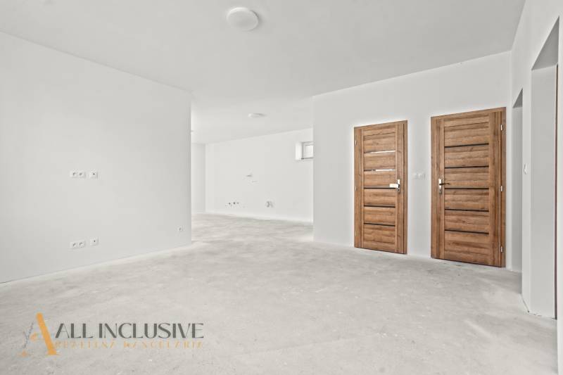 NA PREDAJ 4-IZB.BUNGALOV S DVOJGARÁŽOU,ORECHOVÁ POTôŇ - Biele steny a drevené dvere v interiéri rodinného domu s podlahou bez dekoru.