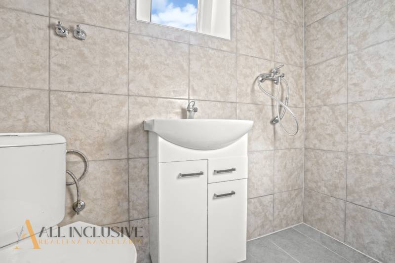 NA PREDAJ 4-IZB.BUNGALOV S DVOJGARÁŽOU,ORECHOVÁ POTôŇ - Kúpeľňa v rodinnom dome s umývadlom, sprchou a toaletou v svetlých obkladoch.