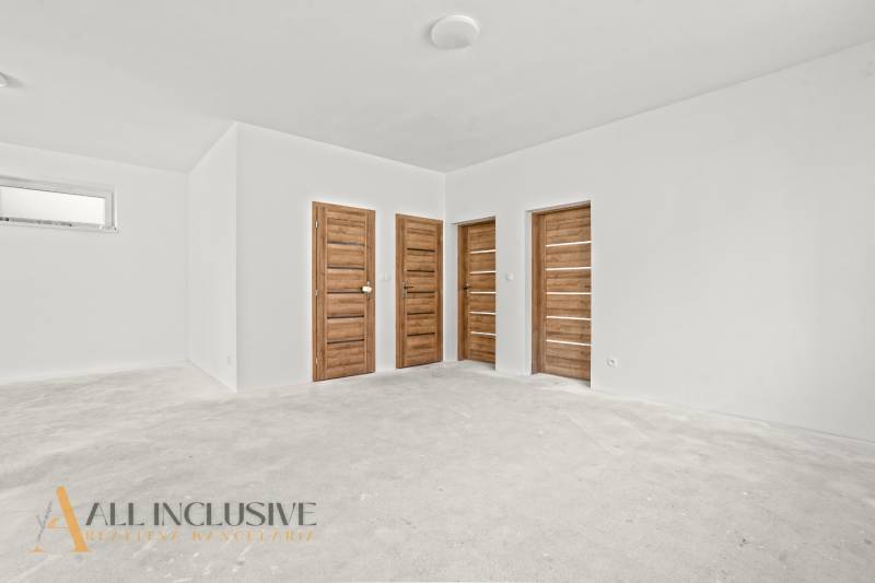 NA PREDAJ 4-IZB.BUNGALOV S DVOJGARÁŽOU,ORECHOVÁ POTôŇ - Priestranná miestnosť v rodinnom dome s bielymi stenami a dverami s dreveným dekorom.