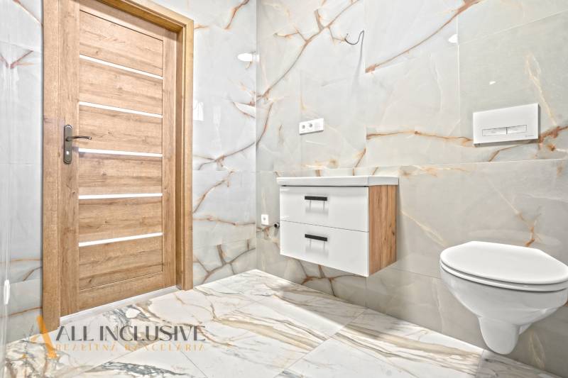 NA PREDAJ 4-IZB.BUNGALOV S DVOJGARÁŽOU,ORECHOVÁ POTôŇ - Kúpeľňa v rodinnom dome s obkladom a podlahou s mramorovým dekorom.