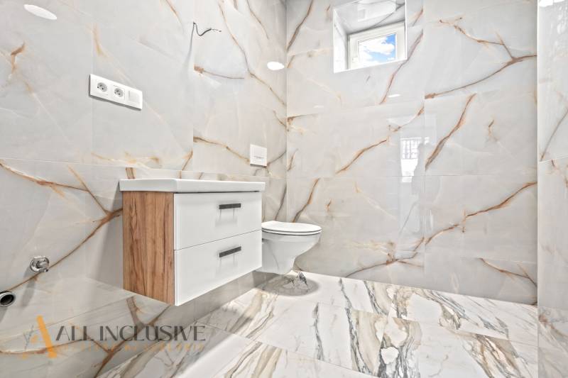 NA PREDAJ 4-IZB.BUNGALOV S DVOJGARÁŽOU,ORECHOVÁ POTôŇ - Kúpeľňa v rodinnom dome s keramickými obkladmi a nábytkom s dreveným dekorom.