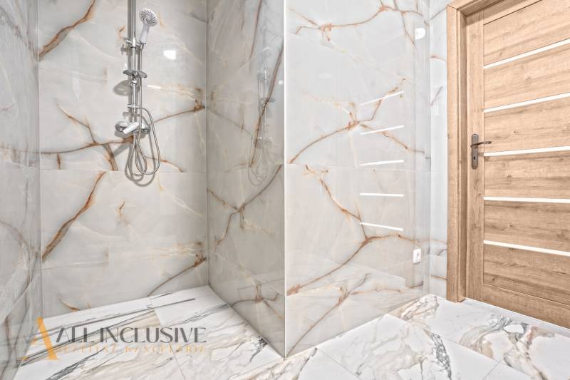 NA PREDAJ 4-IZB.BUNGALOV S DVOJGARÁŽOU,ORECHOVÁ POTôŇ - Kúpeľňa v rodinnom dome s imitáciou mramoru na stenách a drevenými dverami.