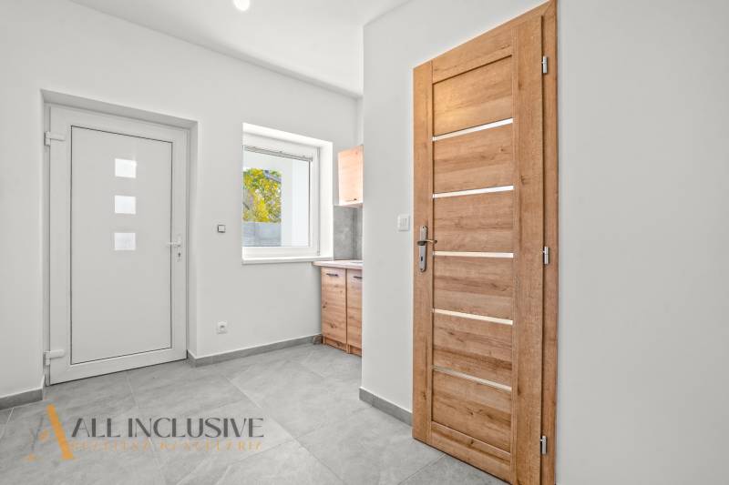 NA PREDAJ 4-IZB.BUNGALOV S DVOJGARÁŽOU,ORECHOVÁ POTôŇ - Biela chodba Rodinného domu s drevenými dverami a keramickou podlahou.