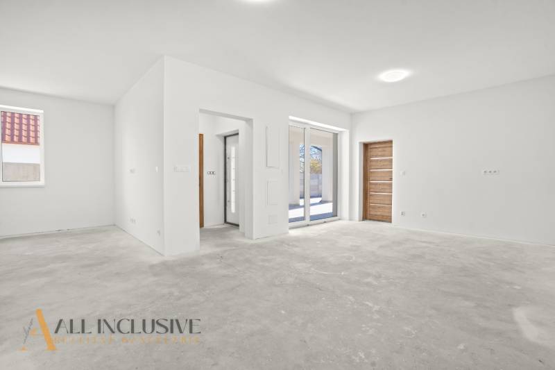 NA PREDAJ 4-IZB.BUNGALOV S DVOJGARÁŽOU,ORECHOVÁ POTôŇ - Priestranný interiér rodinného domu s bielymi stenami a dlažbovou podlahou.