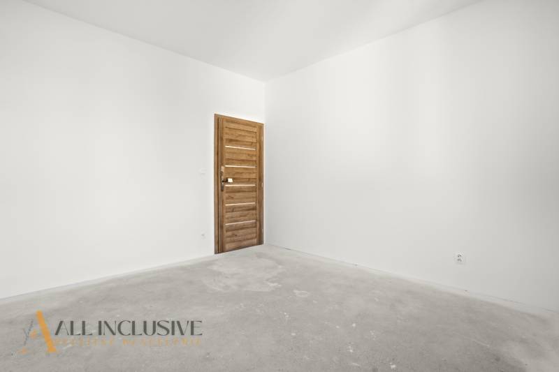 NA PREDAJ 4-IZB.BUNGALOV S DVOJGARÁŽOU,ORECHOVÁ POTôŇ - Miestnosť v rodinnom dome so svetlými stenami a drevenými dverami.