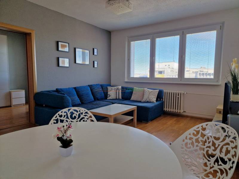 PRENÁJOM zariadený 3-izb byt, Pribišova, Bratislava - Obývačka 3-izbového bytu so sedačkou, bielym stolom a podlahou s dreveným dekorom.