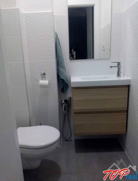 PRENÁJOM - 1,5 izbový byt Košice - Staré mesto - Kompaktná kúpeľňa s umývadlom a skrinkou v 1-izbovom byte, obklady s jemnou textúrou.