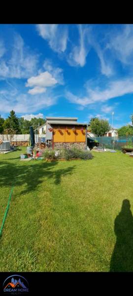  MH280- Na predaj krásna záhrada s chatkou v Komárne! - Záhrada pri chate v Novej osade v Komárne s modrou oblohou a upraveným trávnikom.