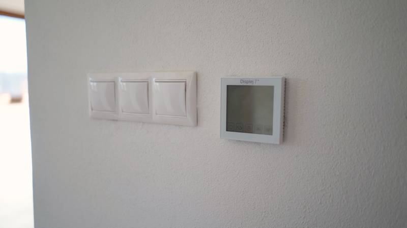 Predaj novostavba rodinného domu   Nová Baňa - Spínače a displej na stene v rodinnom dome.