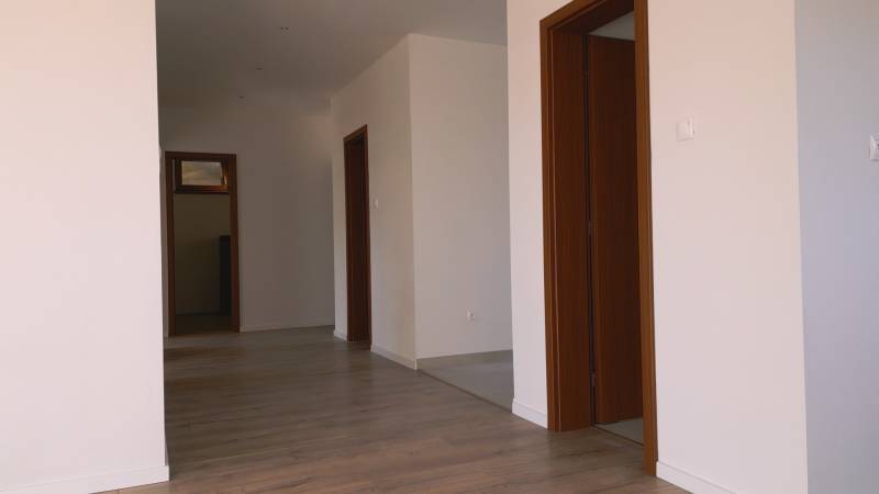 Predaj novostavba rodinného domu   Nová Baňa - Interiér rodinného domu s podlahou s dreveným dekorom a bielymi stenami.