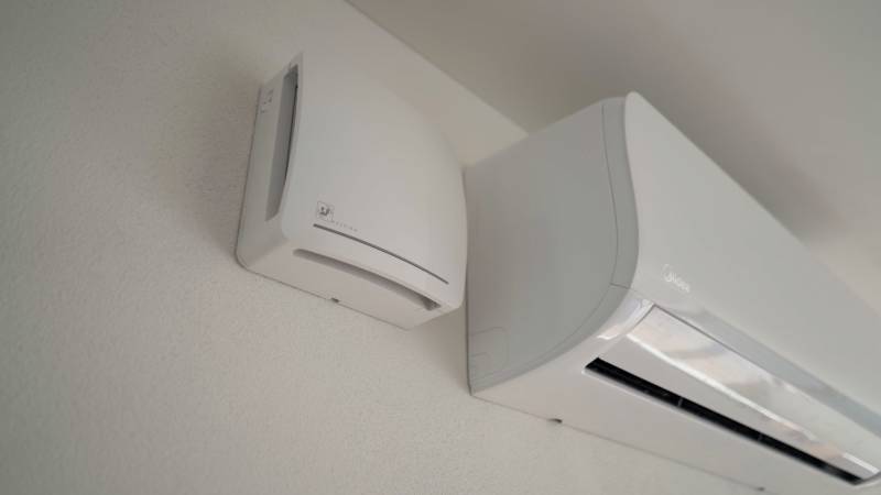 Predaj novostavba rodinného domu   Nová Baňa - Klimatizácia a ventilátor na stene rodinného domu s hladkým bielym povrchom.