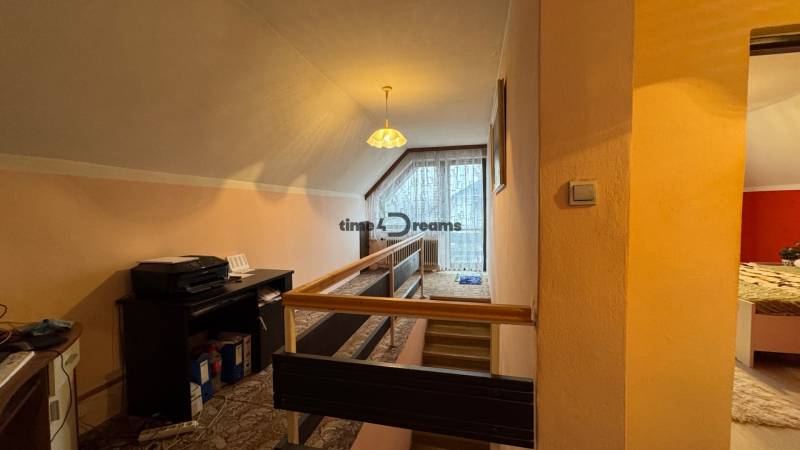 NA PREDAJ veľký rodinný dom v obci Pusté Úľany Sládkovičovo - Chodba v rodinnom dome s kobercom, dreveným zábradlím a veľkým oknom.