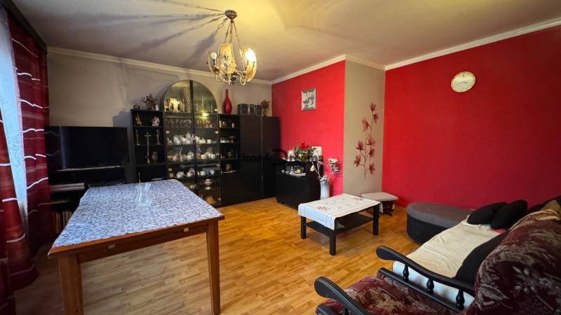 NA PREDAJ veľký rodinný dom v obci Pusté Úľany Sládkovičovo - Obývacia izba v rodinnom dome s drevenou podlahou, červenými stenami a dekoráciami.