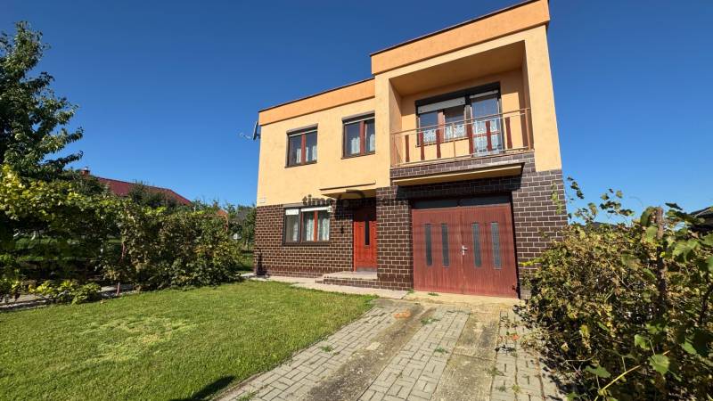 NA PREDAJ 5 izbový rodinný dom v obci Urmince - Topoľčany  - Rodinný dom v Urminciach s tehlovou fasádou a udržiavanou záhradou.