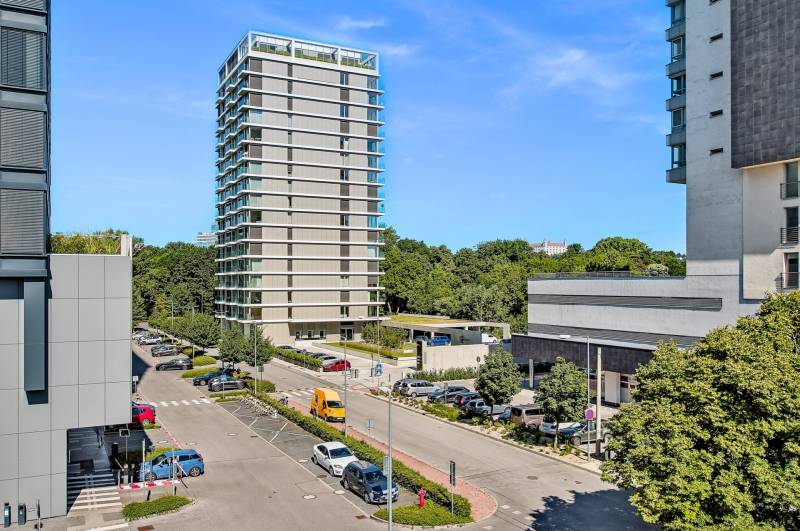 PREDAJ - LIGET Nový 2 izbový apartmán pri Sade Janka Kráľa, Petržalka - Vyhliadka z Krasovského na výškovú budovu, parkovisko a zelenú mestskú scenériu v Bratislave.