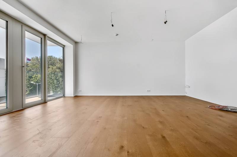 PREDAJ - LIGET Nový 2 izbový apartmán pri Sade Janka Kráľa, Petržalka - Priestranná izba so svetlým drevom a veľkými oknami v 2-izbovom byte.