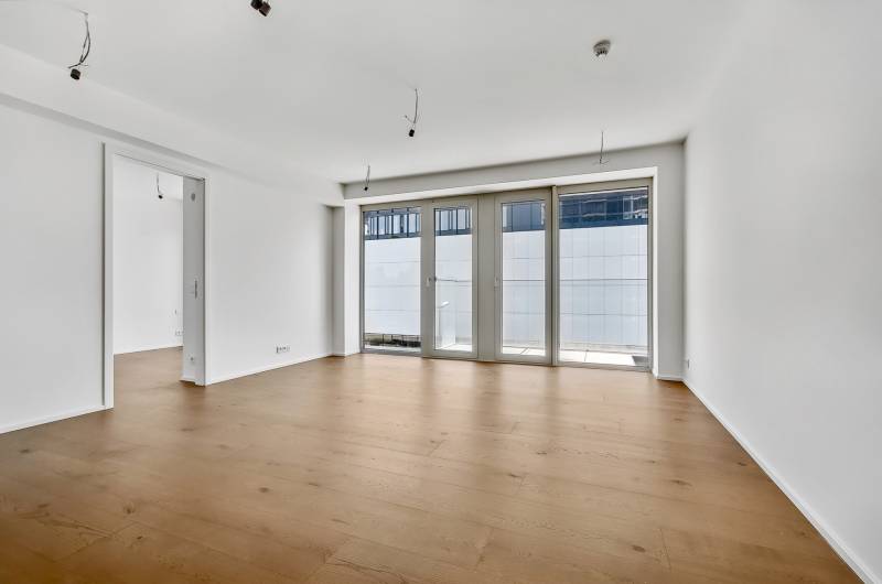 PREDAJ - LIGET Nový 2 izbový apartmán pri Sade Janka Kráľa, Petržalka - Priestranná izba s drevenou podlahou a veľkými francúzskymi oknami v 2-izbovom byte.