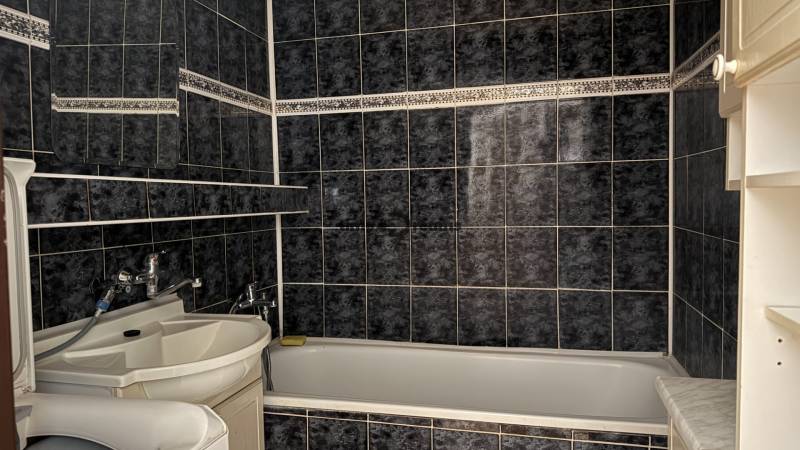 NA PRENÁJOM - 3izb.byt - Zvolenská ul. - Kúpeľňa v 3-izbovom byte s čiernym obkladom a bielym umývadlom.