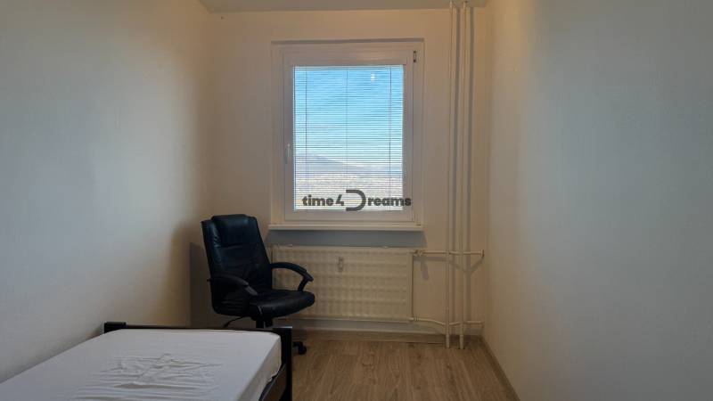 NA PRENÁJOM - 3izb.byt - Zvolenská ul. - Izba v 3-izbovom byte, posteľ, čierne kreslo, podlaha s dreveným dekorom.