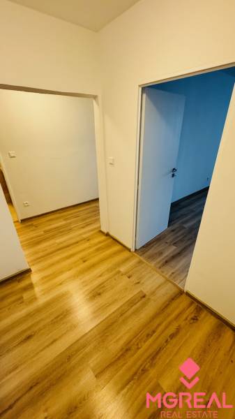 Na prenájom 1 i byt 47 m2 v Partizánskom na sídlisku Luhy 2 x balkón - Interiér s bielymi stenami a podlahou s dreveným dekorom v 1-izbovom byte.