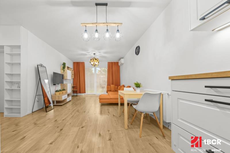 NOVOSTAVBA 2-IZB.BYT,ZÁHRADKA 26 m²,PARK.STÁTIE, MAHULANKA,PEZINOK - Obývačka v 2-izbovom byte s podlahou s dreveným dekorom a oranžovým nábytkom.