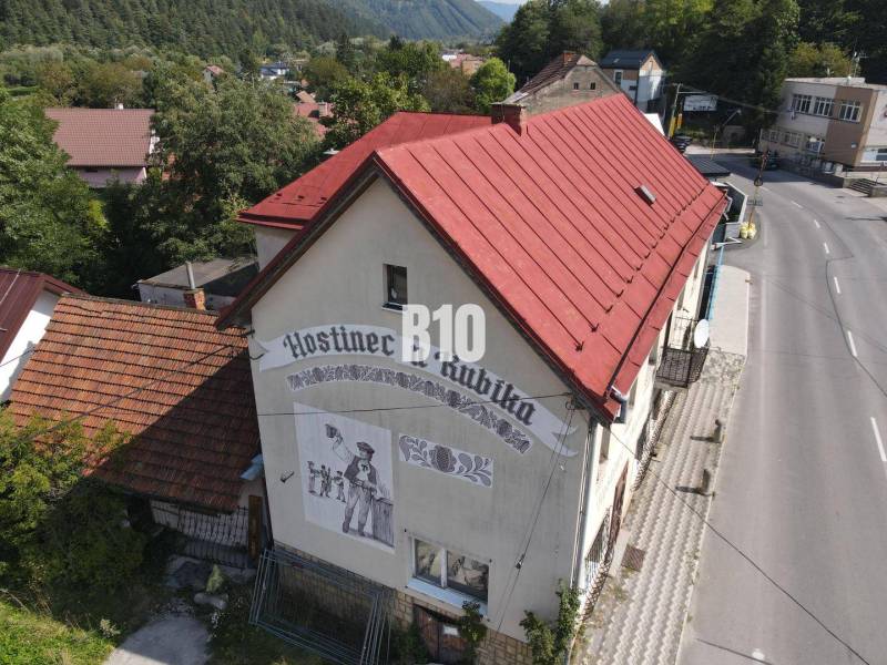 Teraz zľava 30.000 TOP INVESTIČNÁ PRÍLEŽITOSŤ Polyfunkčný objekt na pr - Budova hostinca v Belej s červenou strechou a vyobrazením na stene.