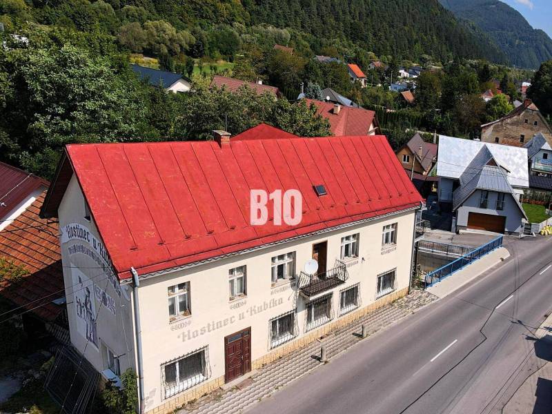 Teraz zľava 30.000 TOP INVESTIČNÁ PRÍLEŽITOSŤ Polyfunkčný objekt na pr - Budova v Belej s červenou strechou na hlavnej ulici obklopená zeleňou a domami.