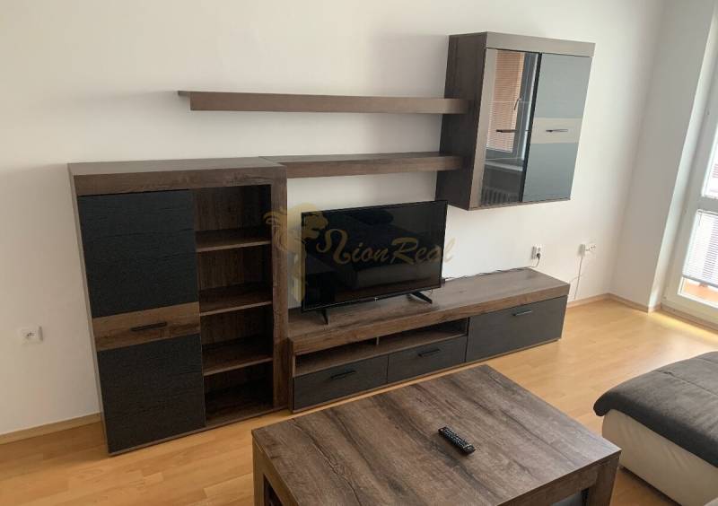 2-izb. byt, Nobelova ul., Nové Mesto, 2.p./7, balkón - Obývacia stena a televízor v 2-izbovom byte s podlahou s dreveným dekorom.