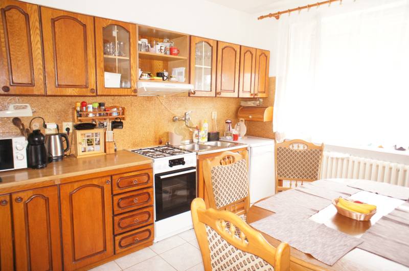 Rodinný dom v obci Čilížska Radváň s veľkým pozemkom - Kuchyňa s dreveným nábytkom, plynový sporák, jedálenský stôl, vhodné pre rodinný dom.