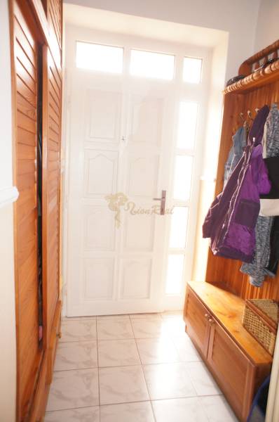 Rodinný dom v obci Čilížska Radváň s veľkým pozemkom - Vstupná hala s bielymi dverami, vešiakom a úložným boxom v rodinnom dome.