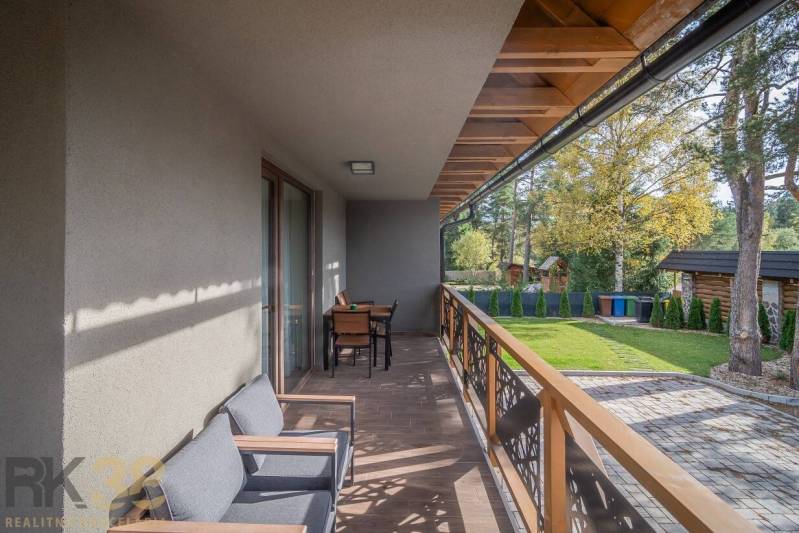 Lukratívne dvoj a štvorizbové byty v Tatranskej Lomnici na prenájom - Balkón 2-izbového bytu v Tatranskej Lomnici s podlahou s dreveným dekorom a záhradným nábytkom.