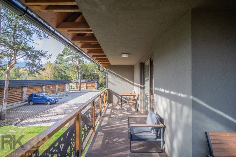 Lukratívne dvoj a štvorizbové byty v Tatranskej Lomnici na prenájom - Balkón 2-izbového bytu v Tatranskej Lomnici s dreveným dekórom a vonkajším sedením.