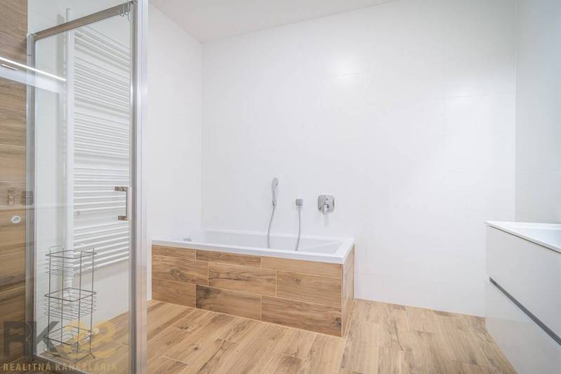 Lukratívne dvoj a štvorizbové byty v Tatranskej Lomnici na prenájom - Kúpeľňa s vaňou a podlahou s dreveným dekorom v 2-izbovom byte.