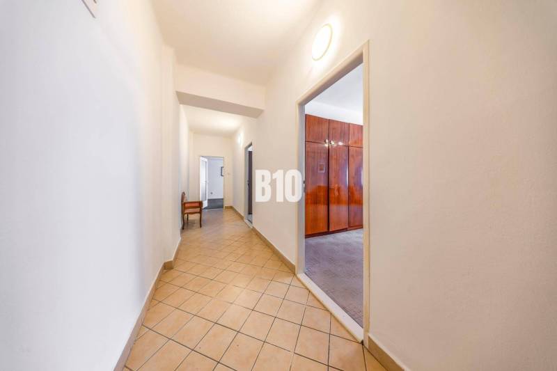 KRÍŽNA: VEĽKORYSÝ 4-IZBOVÝ BYT S RETRO ŠARMOM BLÍZKO CENTRA - Chodba s dlažbou a vstupom do miestnosti v 4-izbovom byte.