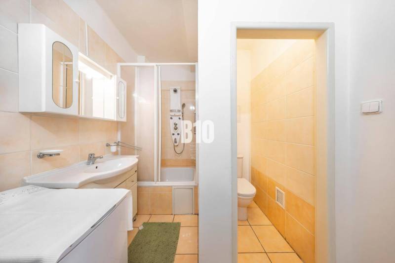 KRÍŽNA: VEĽKORYSÝ 4-IZBOVÝ BYT S RETRO ŠARMOM BLÍZKO CENTRA - Kúpelňa v 4-izbovom byte s vaňou, skrinkami a toaletou, ladená v svetlých farbách.