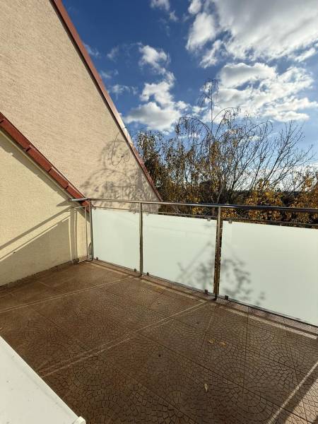 Novinka: Moderný  4-izb. mezonetový byt s balkónom a terasou. Muškát - Balkón 4-izbového bytu na Pekníkovej ulici v Pezinku s výhľadom na koruny stromov.